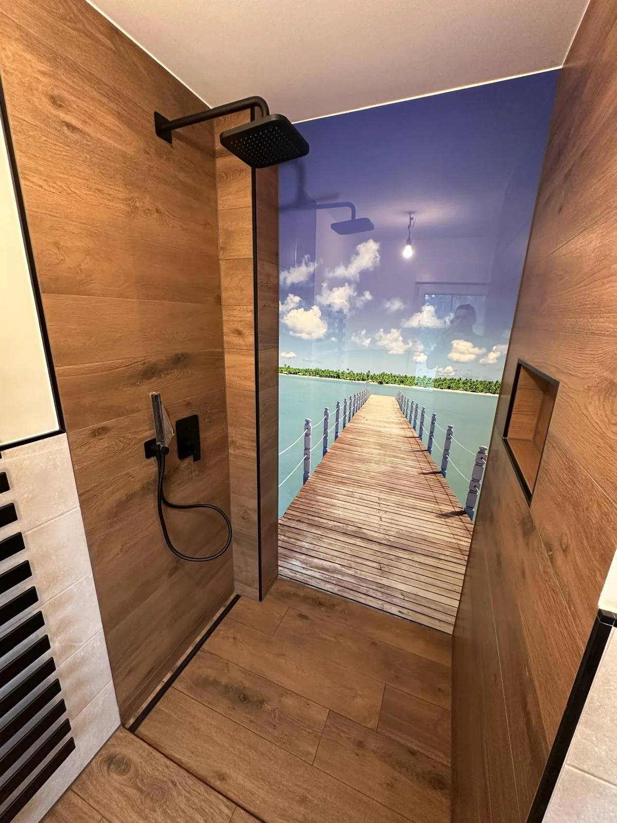 Duschbereich mit Wandgestaltung in Holzoptik, Fotomotiv und Ablagenische